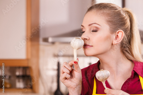 Woman holding and smelling garlic