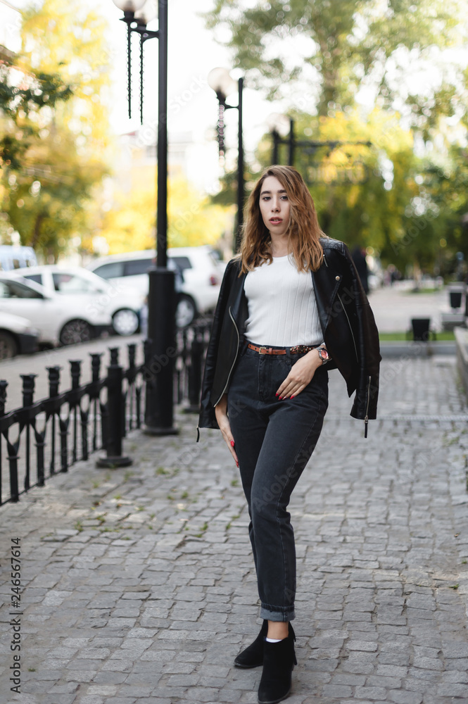 portrait of a young beautiful woman on street, model posing, women's urban street fashion, warm colors