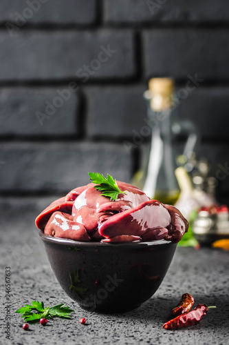 Chicken liver on dark background. Selective focus, space for text.