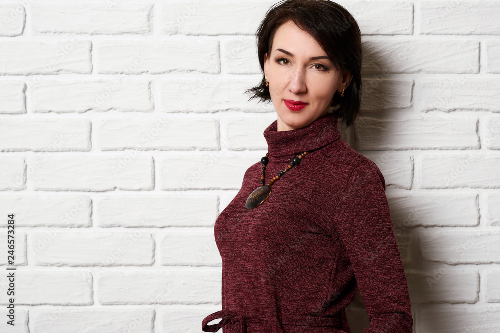 Beautiful woman posing near white brick wall background Beautiful woman posing near white brick wall background