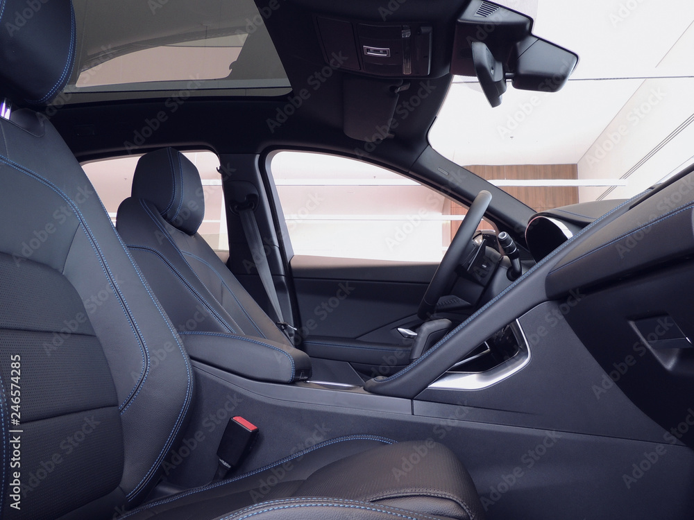 Front black leather trimmed car seats with blue thread stitching Front black leather trimmed car seats with blue thread stitching