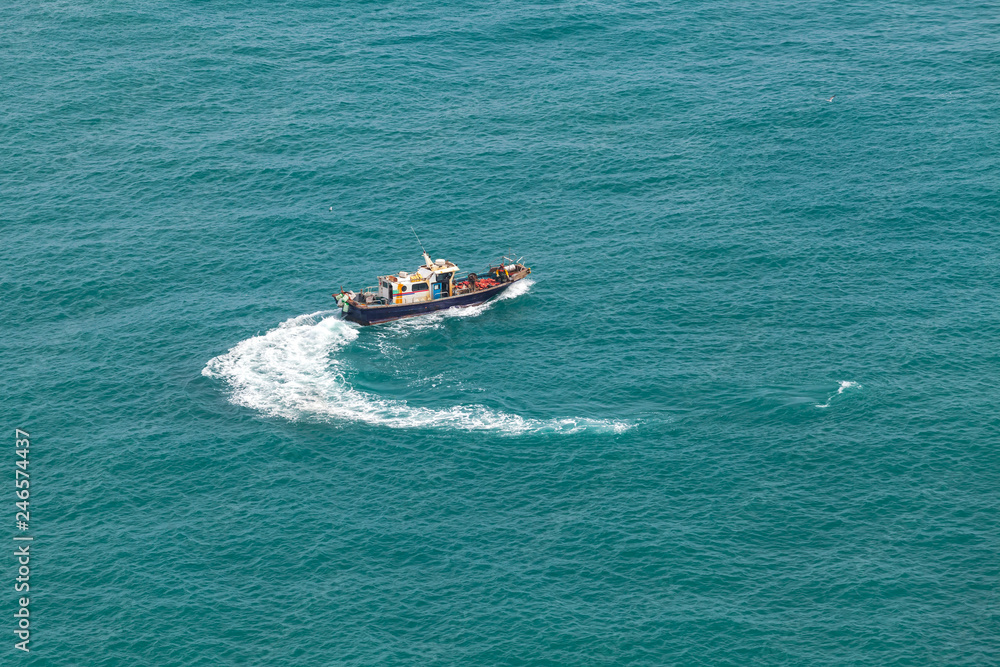 Fototapeta premium Small fishing motorboat boat turns