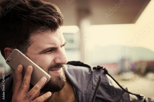 handsome young casual business man with beard using cell phone