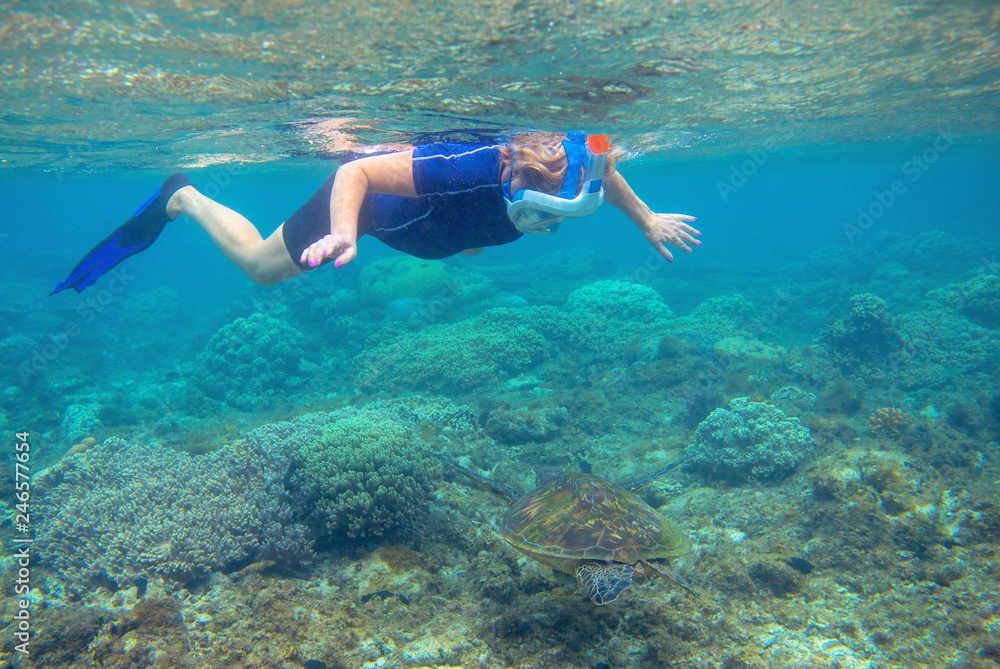 Snorkeling with sea turtle. Snorkel in coral reef of tropical sea. Woman in full-face snorkeling mask