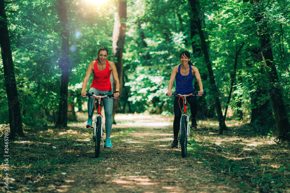 Obraz premium Women Riding Bikes Together