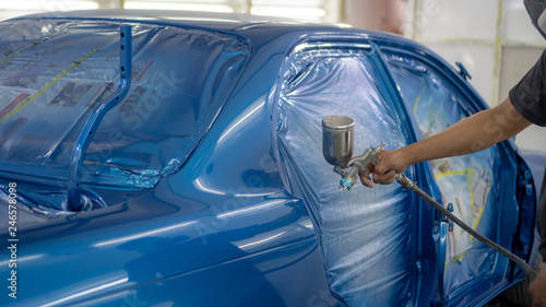 spray gun with paint for painting a car