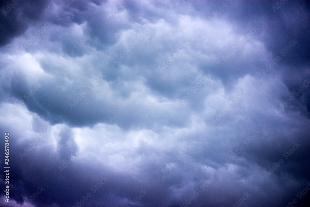 Obraz premium Waiting the storm to come. Heavy dark blue storm clouds in the sky and lightning strikes all around. A rainy night in the middle of summer. Overcast and cold weather