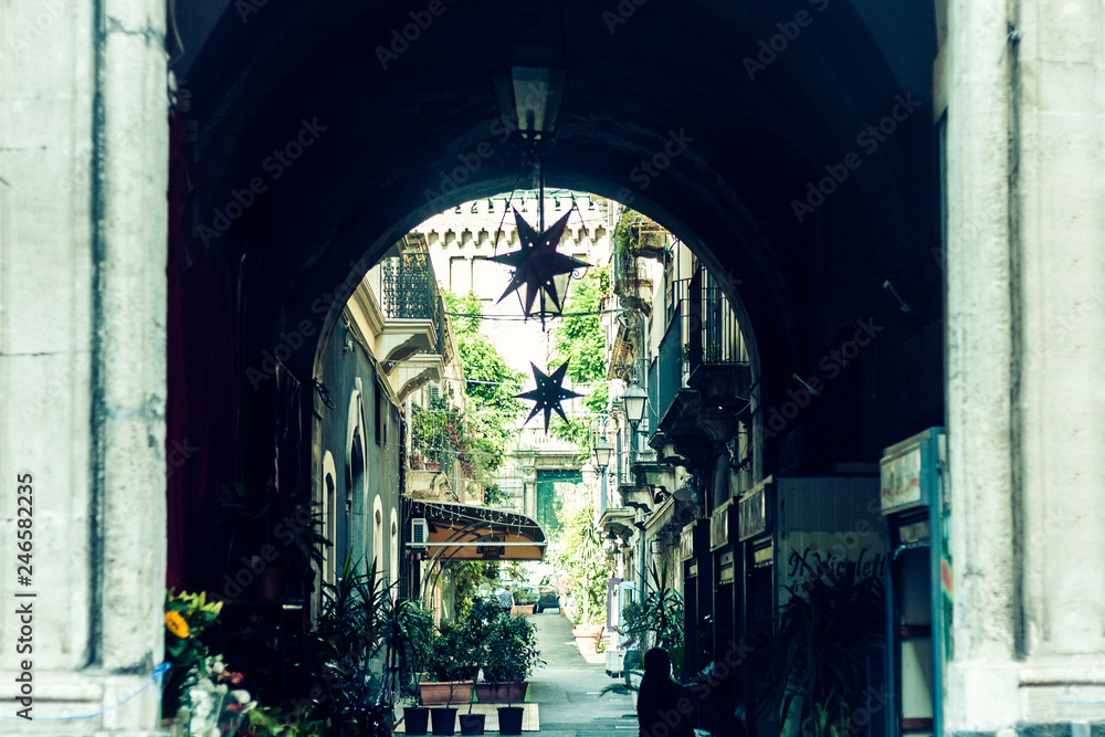 Arch, entrance of old houses, historical street of Catania, Sicily, Italy.