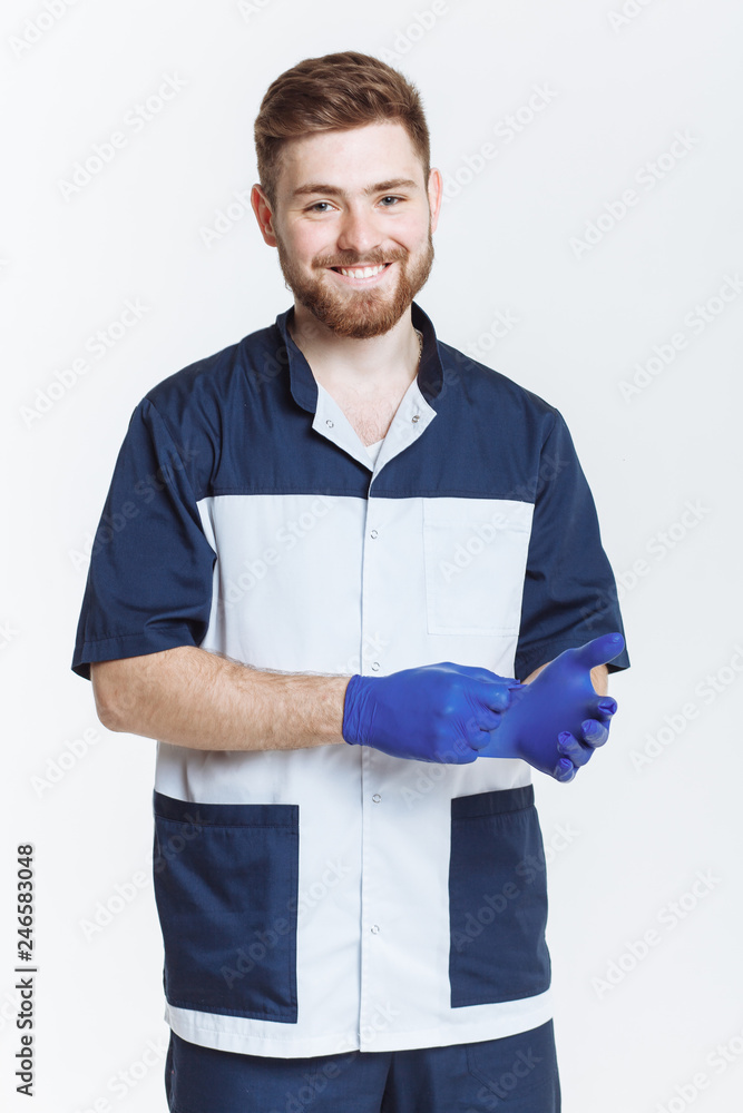 young doctor puts on rubber gloves