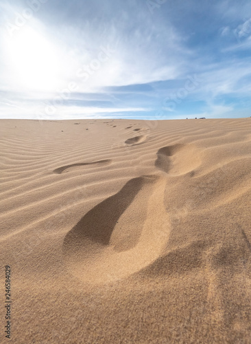 Footprints on a sand with ground waves on white sand dune desert , Mui Ne, Vietnam © somchairakin