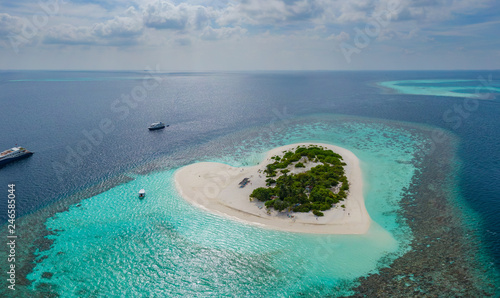 Fototapeta Naklejka Na Ścianę i Meble -  Aerial panoramic view on heart shaped tropical island in blue sea at Maldives background