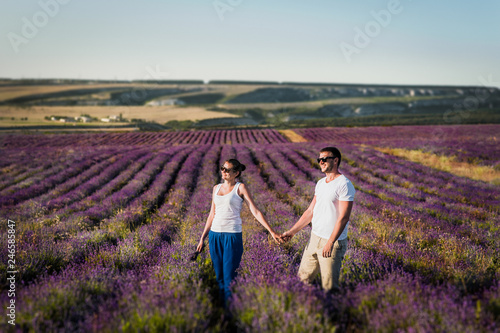 Couple in love on lavender fields. Boy and girl in the flower fields. Honeymoon trip. Honeymoon. Newly married couple. Couple travels. Lavender meadows. Lover. Happy couple. Lover holding hands