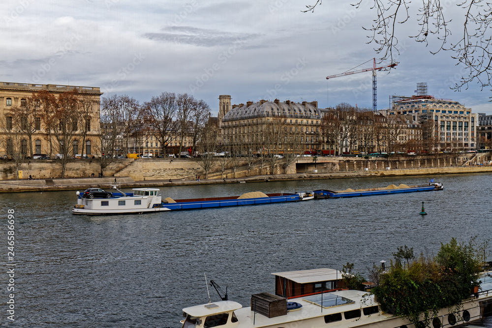 Naklejka premium 18 DEC 2018 - Paris, France - Barge coming down the Seine river