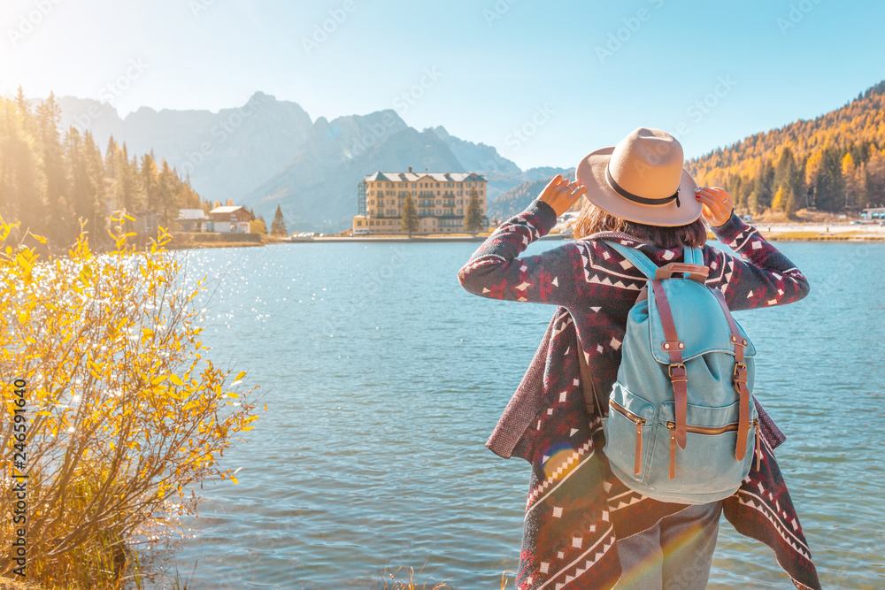 Young happy asian woman travel at the famous tourist destination in Dolomites mountains - Misurina lake during autumn.
