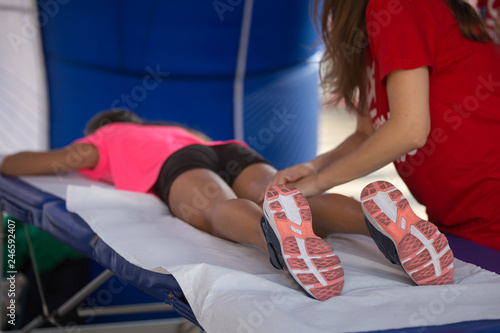 Athlete lying on a Bed while having Legs Massaged after a Physical Sports Workout © GioRez
