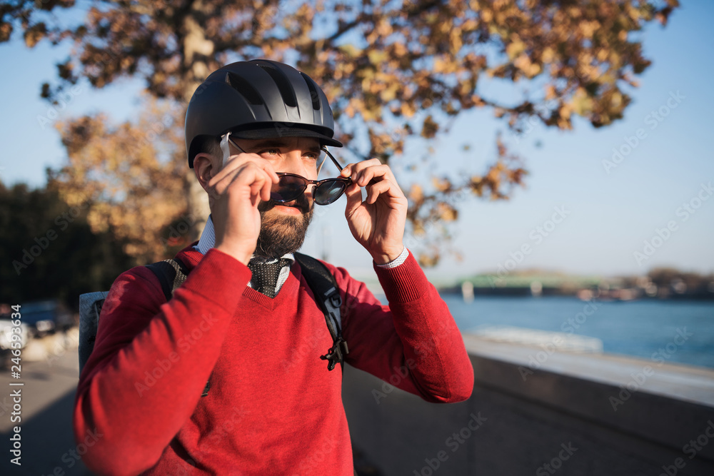 Businessman commuter with bicycle helmet and sunglasses on the way to work in city. Businessman commuter with bicycle helmet and sunglasses on the way to work in city.