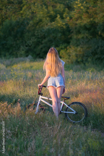 young woman with bicycle in park