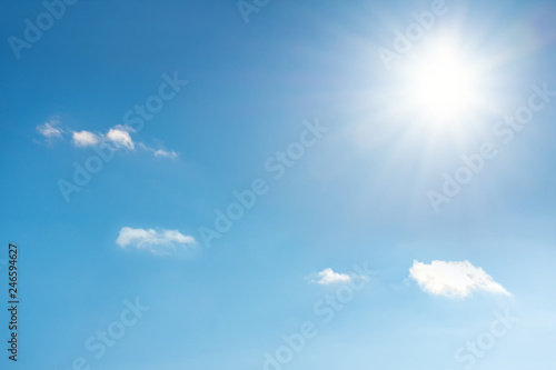 Sun with sunrays on the blue sky with white clouds. Daytime and good weather