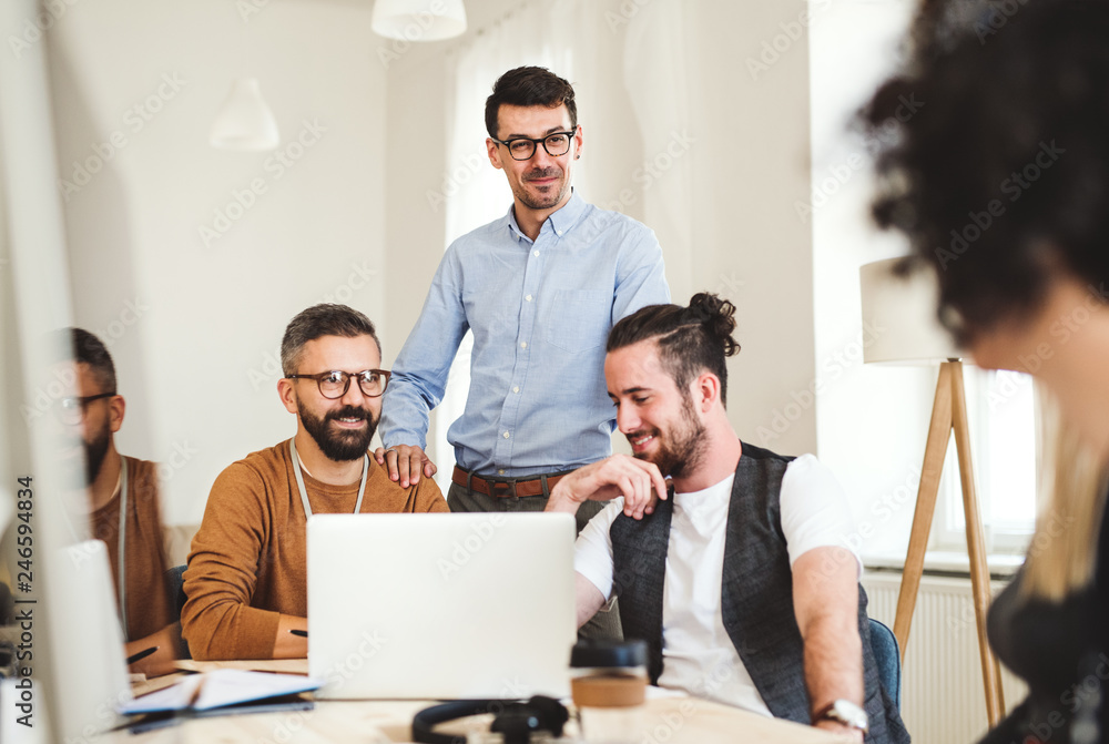 Group of young businesspeople sitting around table in a modern office, having meeting. Group of young businesspeople sitting around table in a modern office, having meeting.