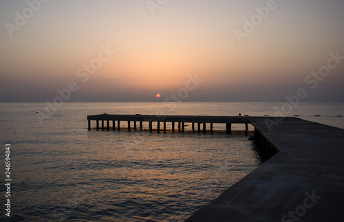 old wooden pier in the sea at sunset 