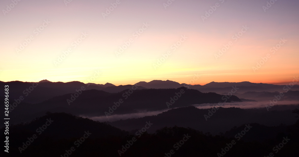 Fototapeta Beautiful sunrise in mountains with white fog below.Wonderful morning high in the mountains with clouds below the mountain tops in the valleys. Colorful wild nature landscape.