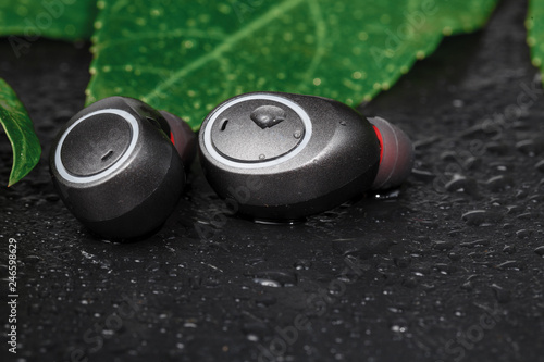 Waterproof headphones, earphones black, beaded with water. Headphones for running in the rain