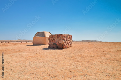 stone wells with water in the desert, against the background of a low elevation