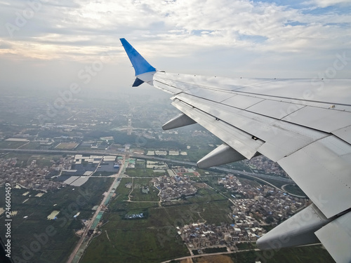 View from the window of an airplane taking off with a wing - a flight over the city.