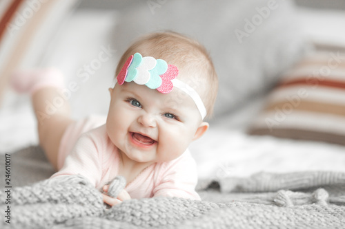 Cute litttle baby at home in the bedroom. An infant indoors. 6th month child portrait. Adorable cute baby girl. photo