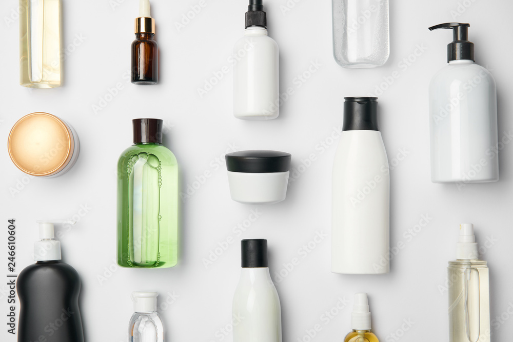 Top view of different cosmetic bottles and container on white background - obrazy, fototapety, plakaty 