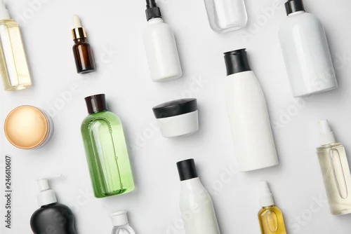 Fototapeta na wymiar Top view of various cosmetic bottles and containers on white background