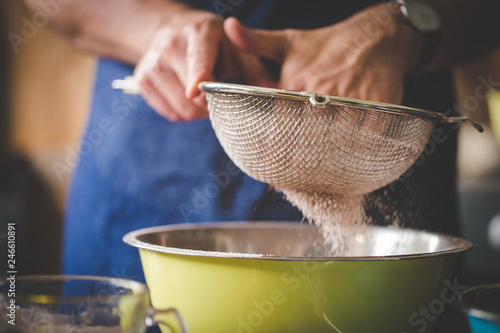 Valokuva Close up image of a chef sifting together flour and ingredients to bake a delicious cake