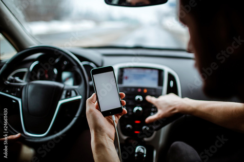 The man presses buttons in the car.The man presses buttons . On the background of the car.Warm light.