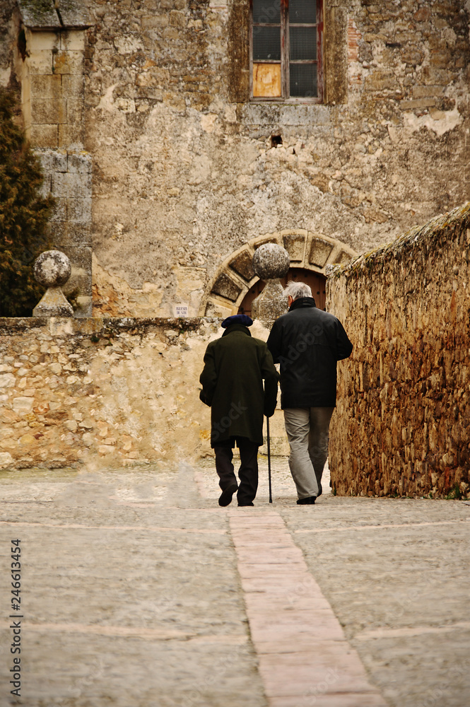 Two people walking through medieval village