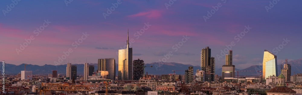 Obraz premium Widok na panoramę Mediolanu o zachodzie słońca z Alpami w tle.