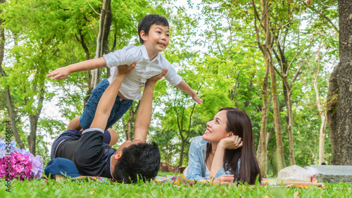 Family Picnic at gaden park Outdoors Togetherness Relaxation Concept with father carrying the kid. photo