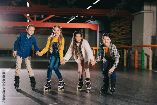 Adorable smiling children preparing to start moving on roller skates photo