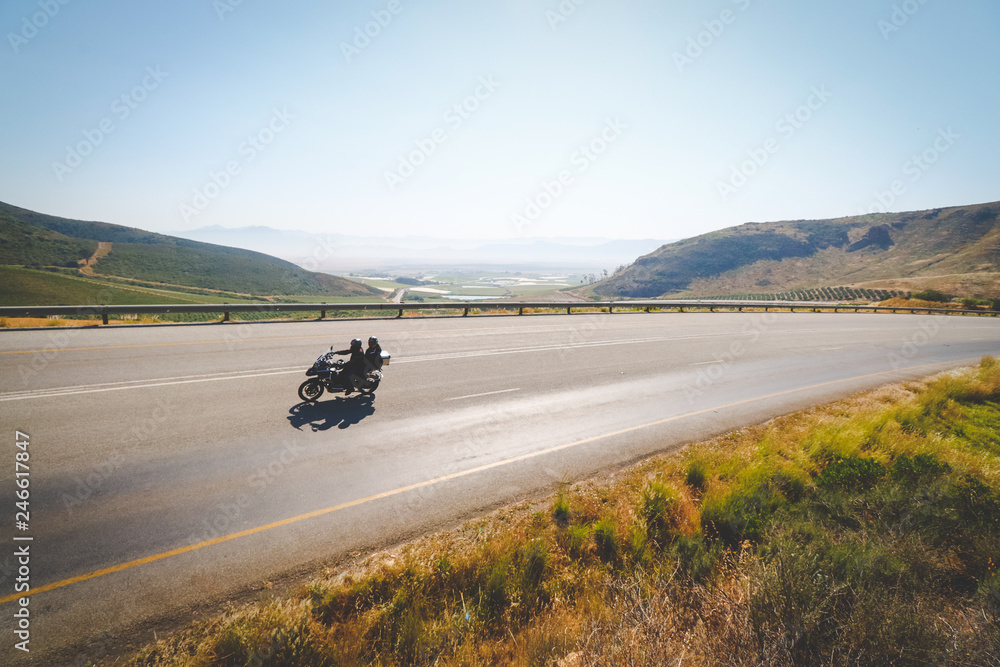 Fototapeta premium Wide angle view of an adventure bike rider enjoying the open road in the western cape of south africa