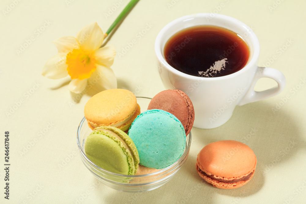 Cup of coffee and delicious macarons cakes of different color on plate. Cup of coffee and delicious macarons cakes of different color on plate.
