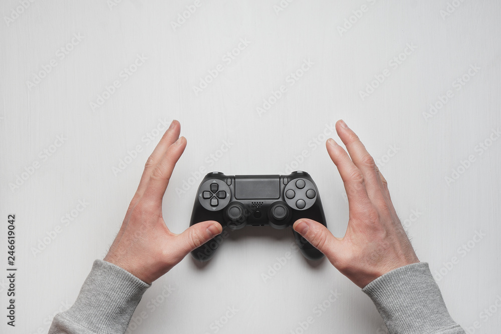 Hand hold new joystick isolated. Gamer play game with gamepad controller. Gaming man holding simulator joypad. Person with joystic in arms. Sleeve hands hold toy equipment. Modern manipulator. Stock Photo
