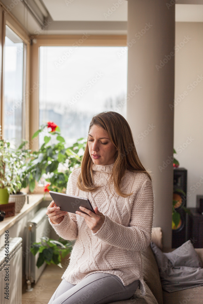Portrait of a young woman using digital tablet indoors Portrait of a young woman using digital tablet indoors