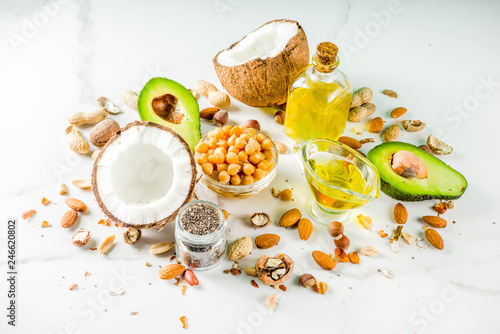 Healthy vegan fat food sources, omega3, omega6 ingredients - almond, pecan, hazelnuts, walnuts, olive oil, chia seeds, avocado, coconut,  banner copy space photo