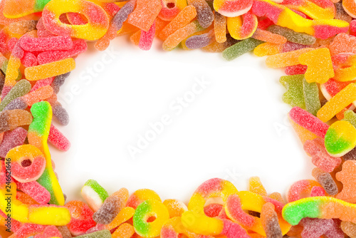 Frame of assorted gummy candies isolated on white. Top view. Space for text or design.