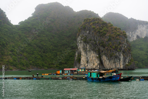 Halong Bay in mystical clouds. Traditional fishermens village in ther sea. Mystical atmoshpere in the world famous halong bay.