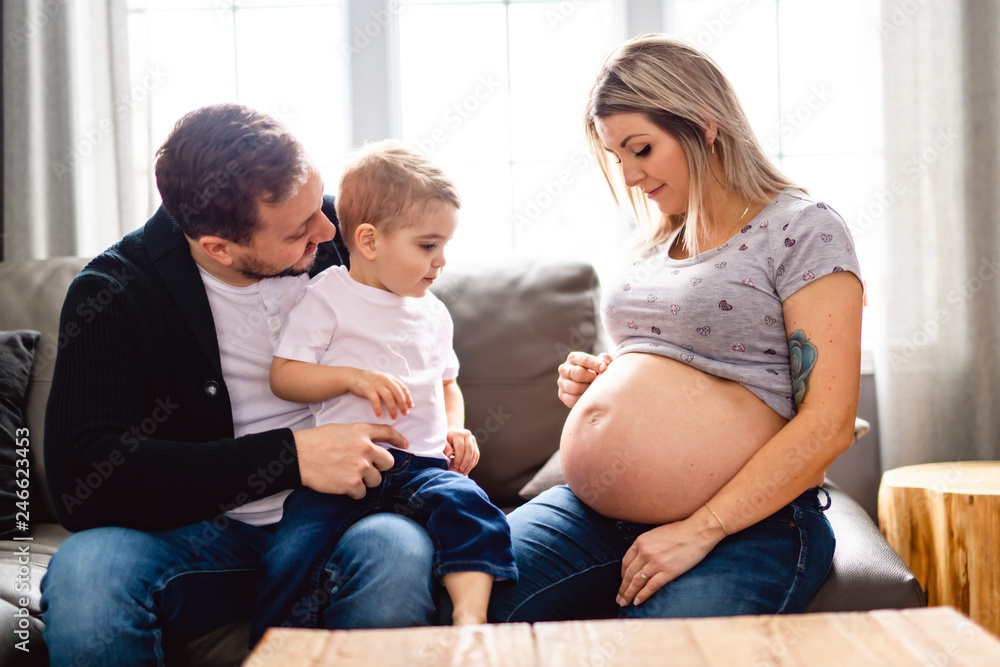 A Beautiful pregnant mother and father with her children at the living room A Beautiful pregnant mother and father with her children at the living room
