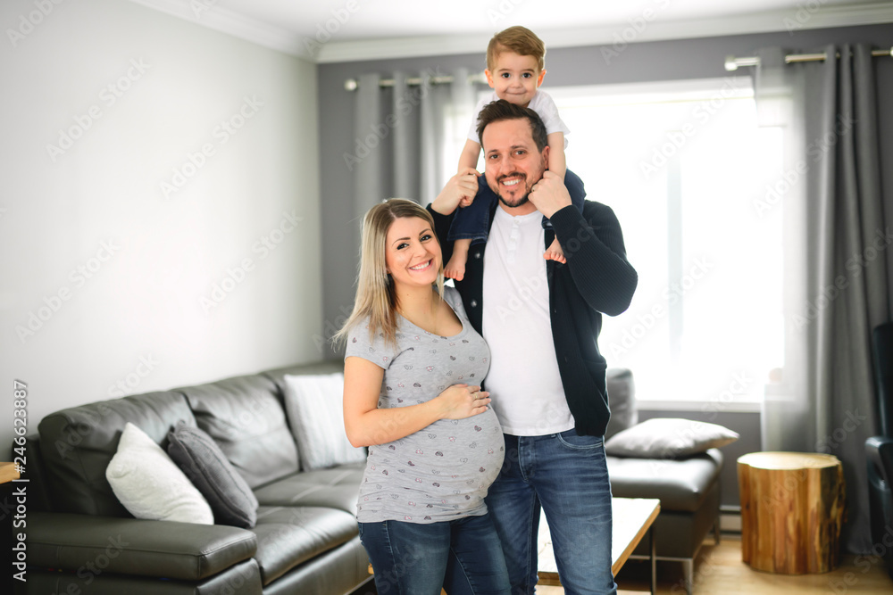 Obraz premium A Beautiful pregnant mother and father with her children at the living room