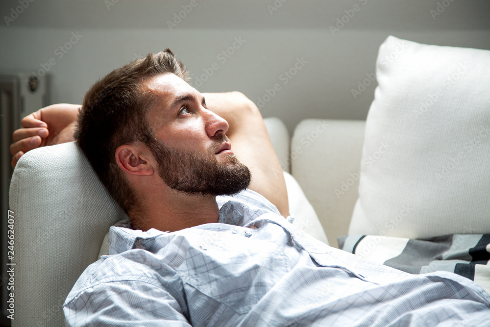 Attraktiver bärtiger Mann entspannt sich auf der Couch Attraktiver bärtiger Mann entspannt sich auf der Couch