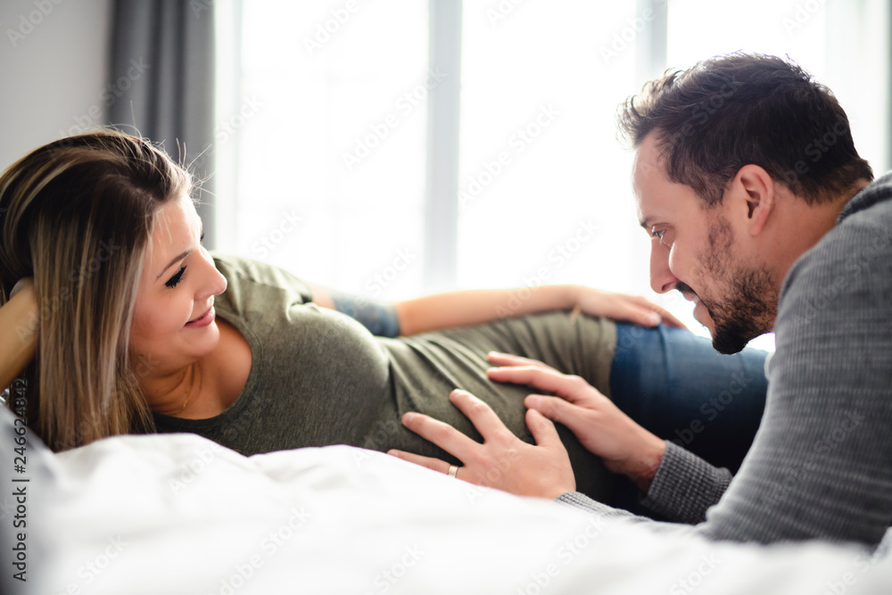 Obraz premium The parents in bed expecting a little baby, Romantic moments for pregnant couple