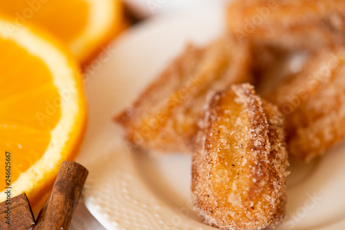 Spanish cuisine: churos and orange close-up on the table