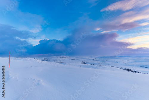 Colors of the North. A beautiful frozen landscape in Russia's Kola peninsula, above the Arctic Circle. The red pole on the far left actually signals where the road ends. © Niccolo